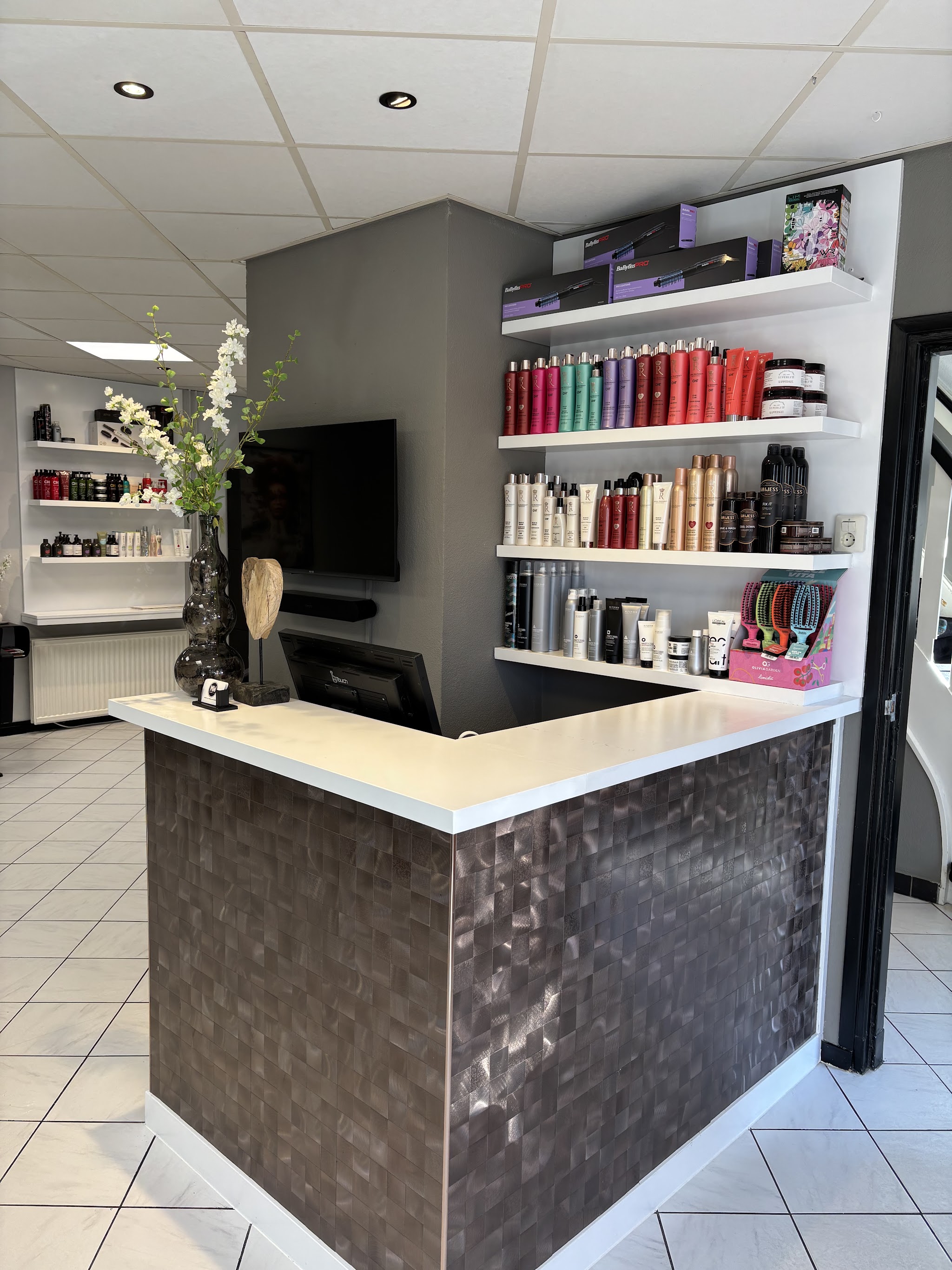 De ontvangstbalie met bloemen en haarverzorgingsproducten in de salon